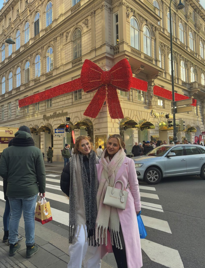 At the famous big red bow that is hung up during Christmas time with my sister who came to visit me!